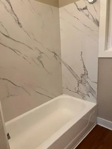 a bathroom with a bath tub with a shower