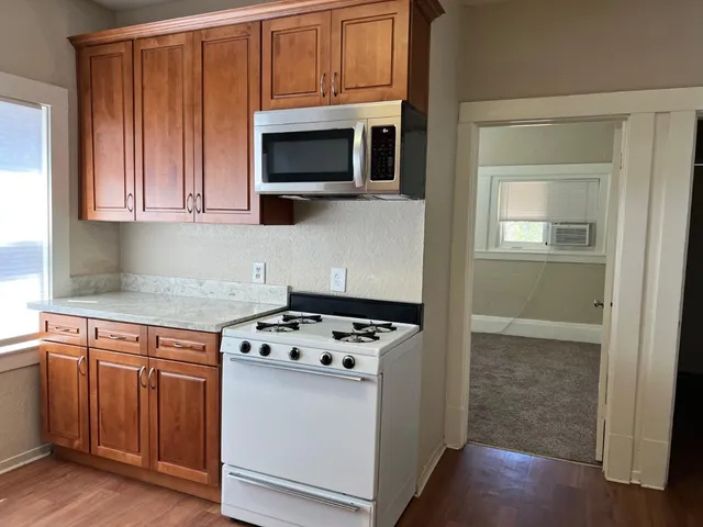 a kitchen with stainless steel appliances granite countertop a sink a refrigerator and cabinets