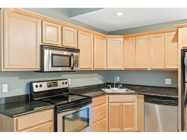 a kitchen with granite countertop a sink stove and cabinets