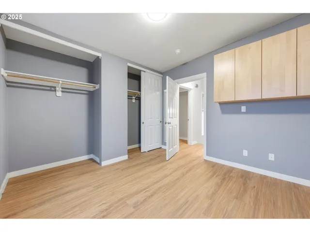 a view of an empty room with closet and a window