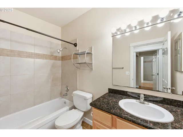 a bathroom with a granite countertop sink toilet a mirror and shower