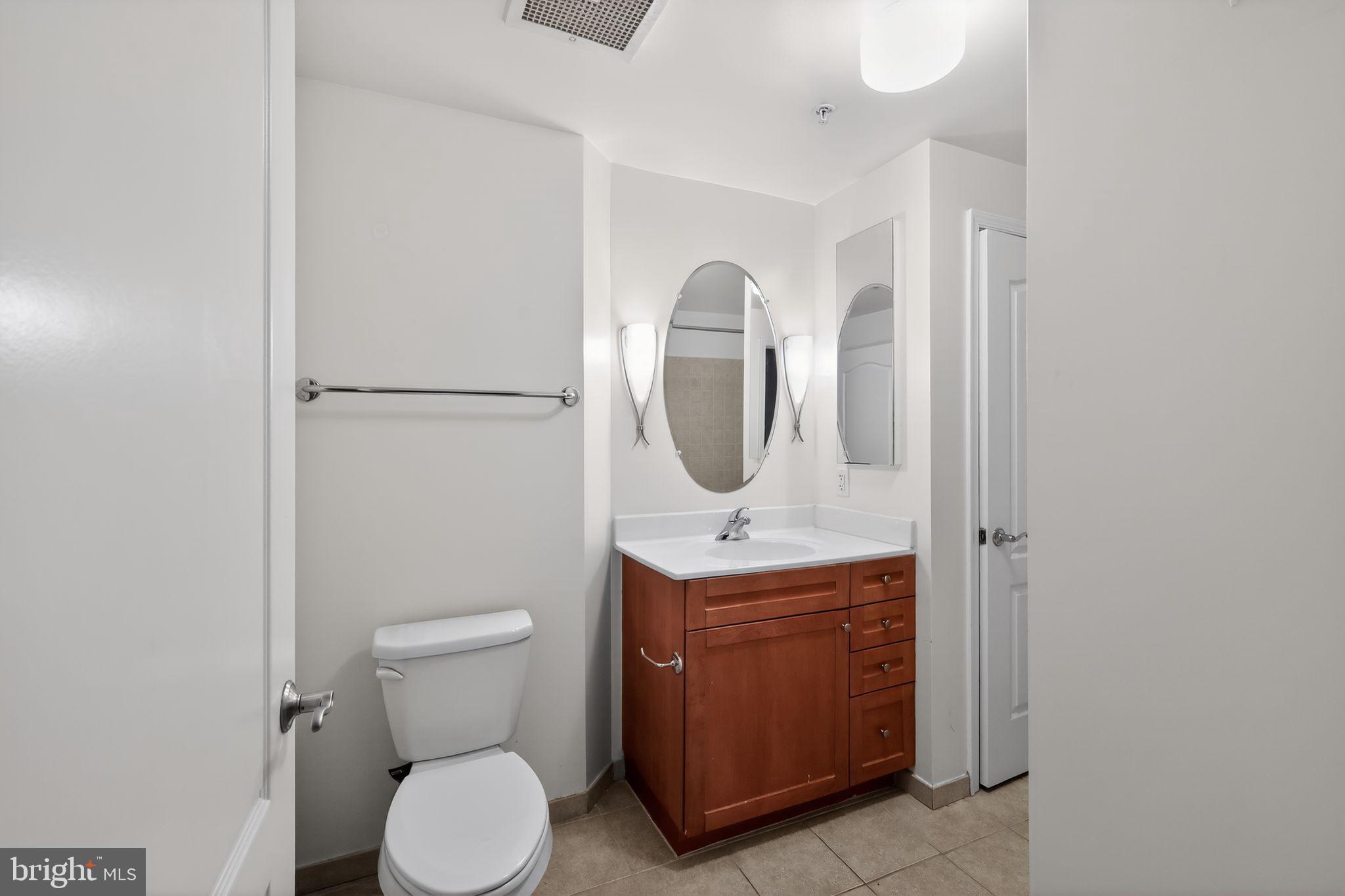 1111 11th Street Northwest, Unit 308 Washington, DC 20001 - Photo 21 of 47 a bathroom with a toilet a sink and mirror
