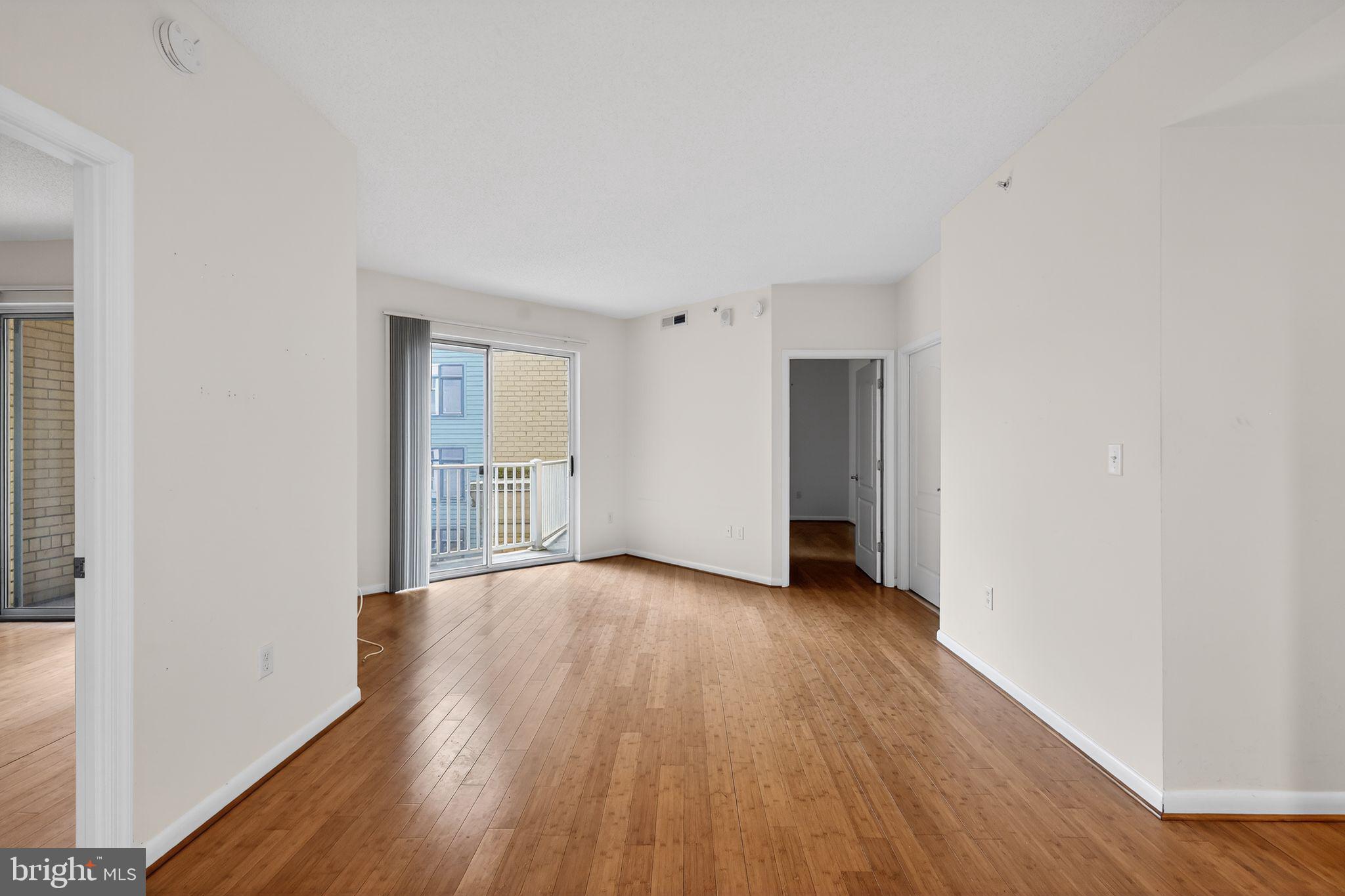 1111 11th Street Northwest, Unit 308 Washington, DC 20001 - Photo 4 of 47 a view of an empty room with wooden floor and a window