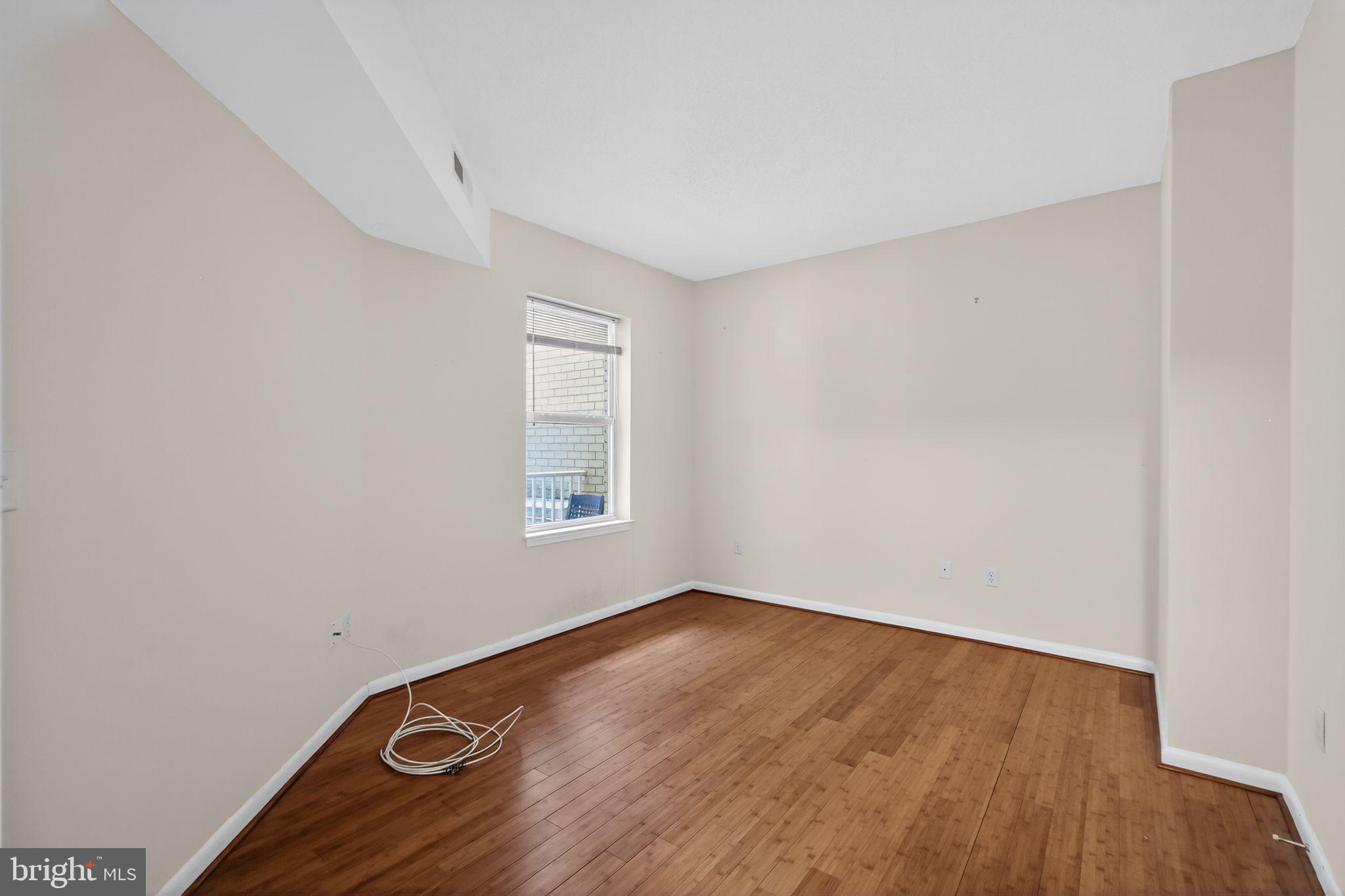 1111 11th Street Northwest, Unit 308 Washington, DC 20001 - Photo 7 of 47 an empty room with wooden floor and windows