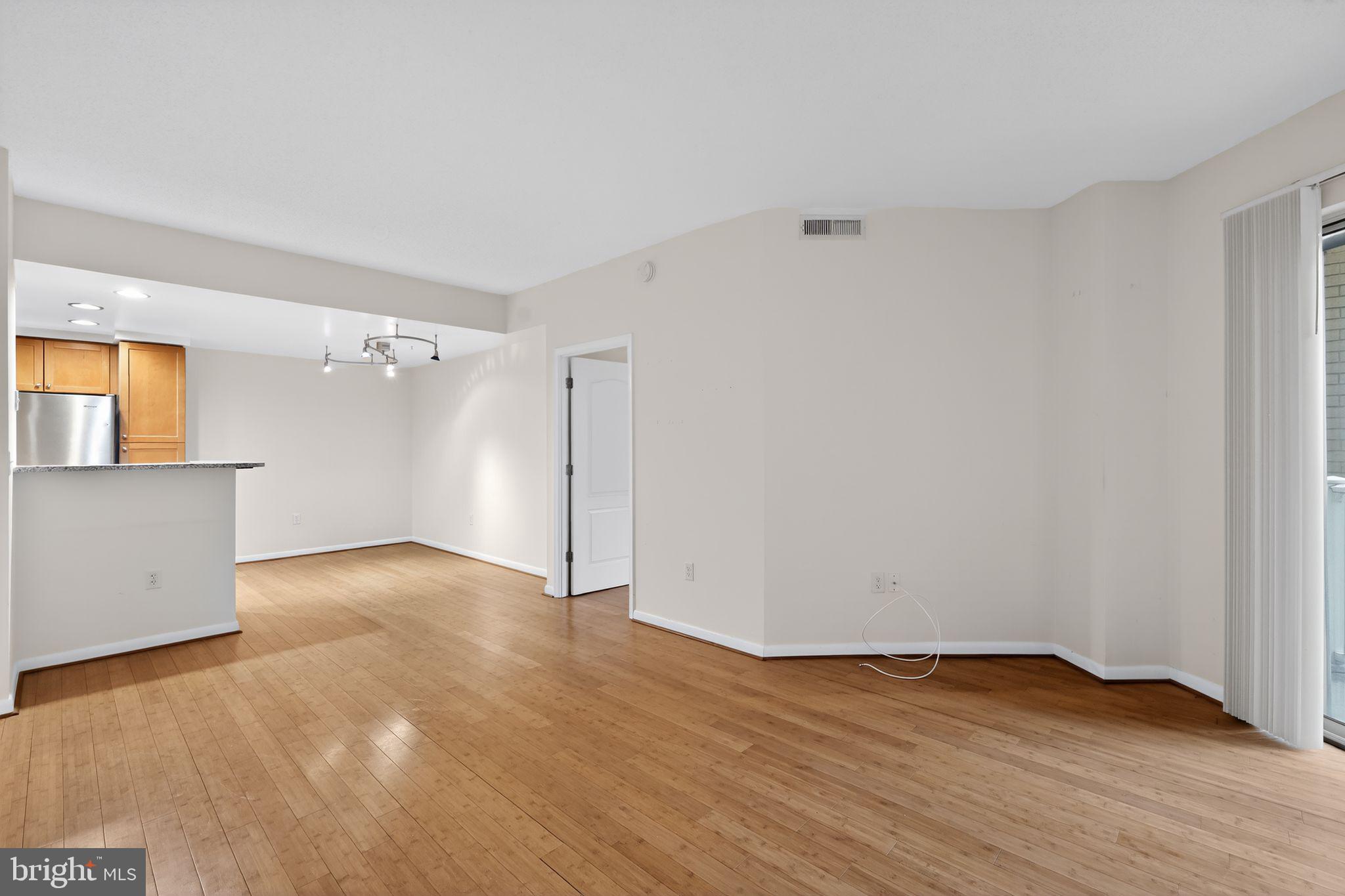 1111 11th Street Northwest, Unit 308 Washington, DC 20001 - Photo 9 of 47 a view of an empty room with wooden floor and a window