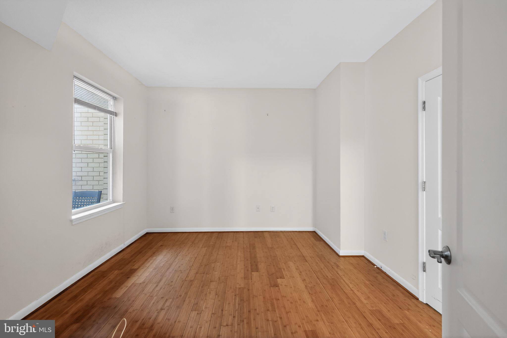 1111 11th Street Northwest, Unit 308 Washington, DC 20001 - Photo 10 of 47 an empty room with wooden floor and windows
