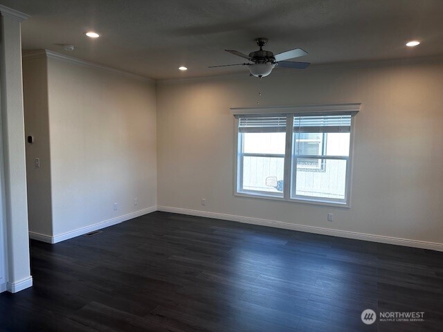 2101 South 324th Street, Unit 174 Federal Way, WA 98003 - Photo 4 of 9 an empty room with wooden floor fan and windows
