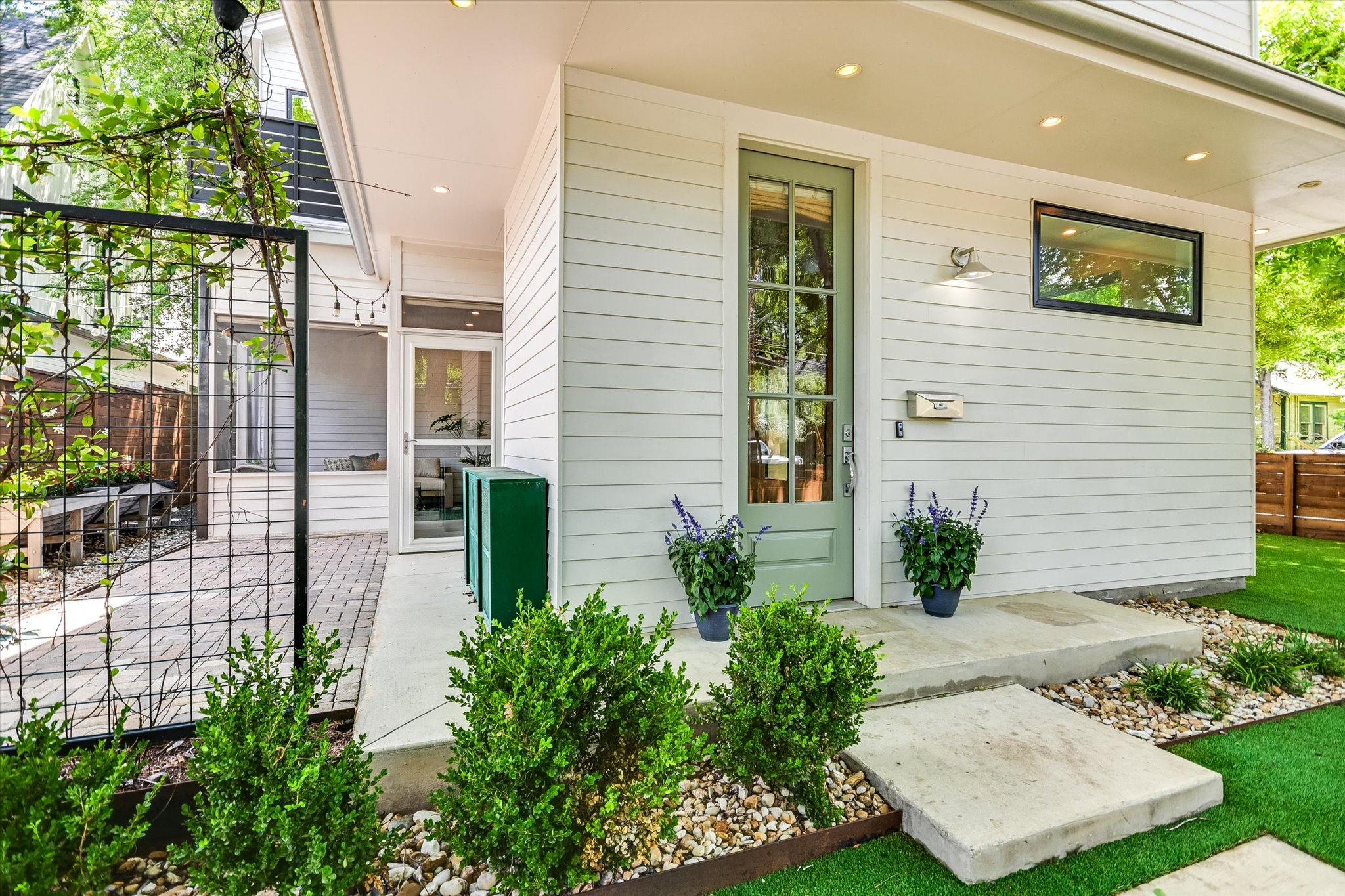 1605 Hether Street Austin, TX 78704 - Photo 5 of 26 Exterior entry featuring a light green full-lite door, white horizontal siding, and a black-framed horizontal window