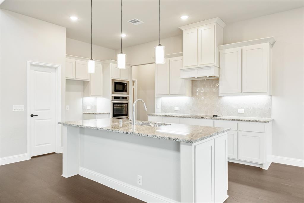 4021 Eagles Bluff Road Midlothian, TX 76065 - Photo 11 of 40 a kitchen with kitchen island granite countertop a sink a center island stainless steel appliances and cabinets
