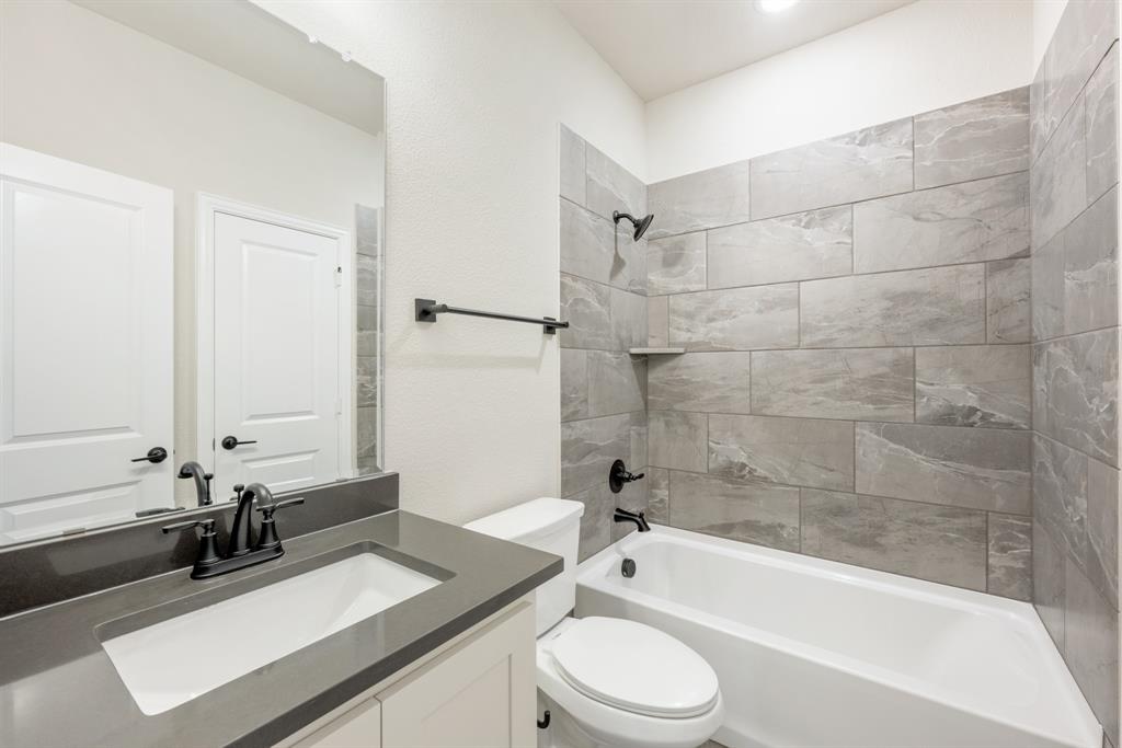 4021 Eagles Bluff Road Midlothian, TX 76065 - Photo 26 of 40 a bathroom with a bathtub a sink a toilet and a mirror