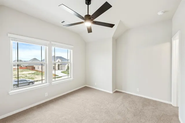 an empty room with windows and fan