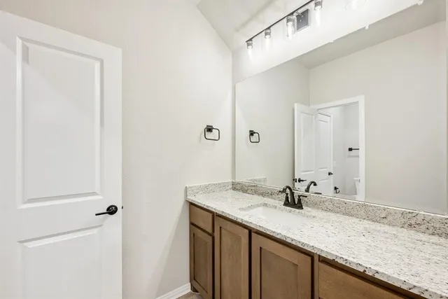 a bathroom with a granite countertop sink and a mirror