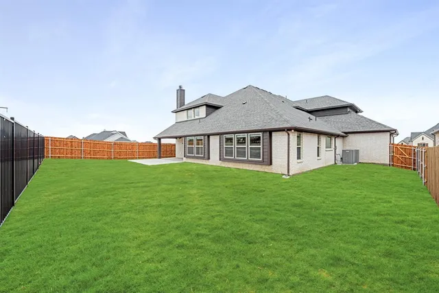 a aerial view of a house next to a big yard and large trees