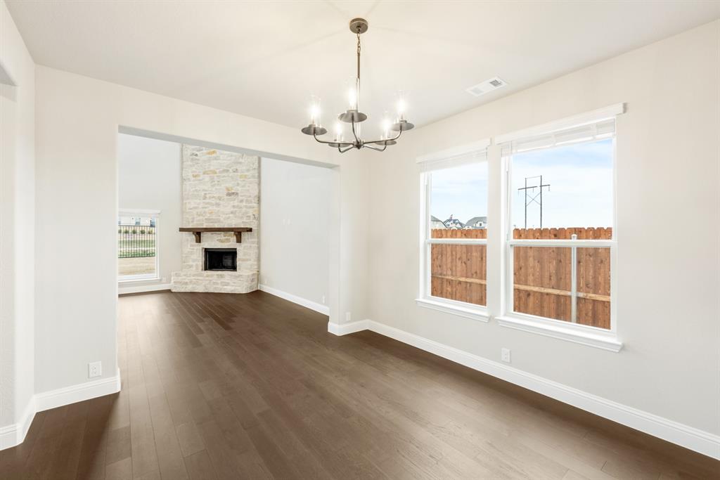 4021 Eagles Bluff Road Midlothian, TX 76065 - Photo 7 of 40 an empty room with wooden floor fireplace and windows