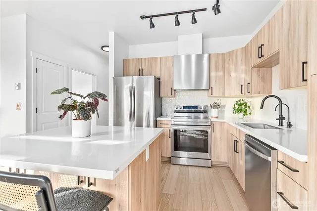 a kitchen with stainless steel appliances a sink stove and refrigerator