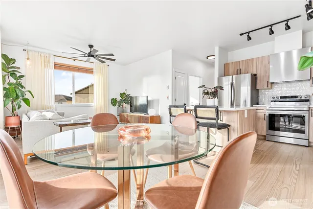a dining room with furniture a large window and wooden floor