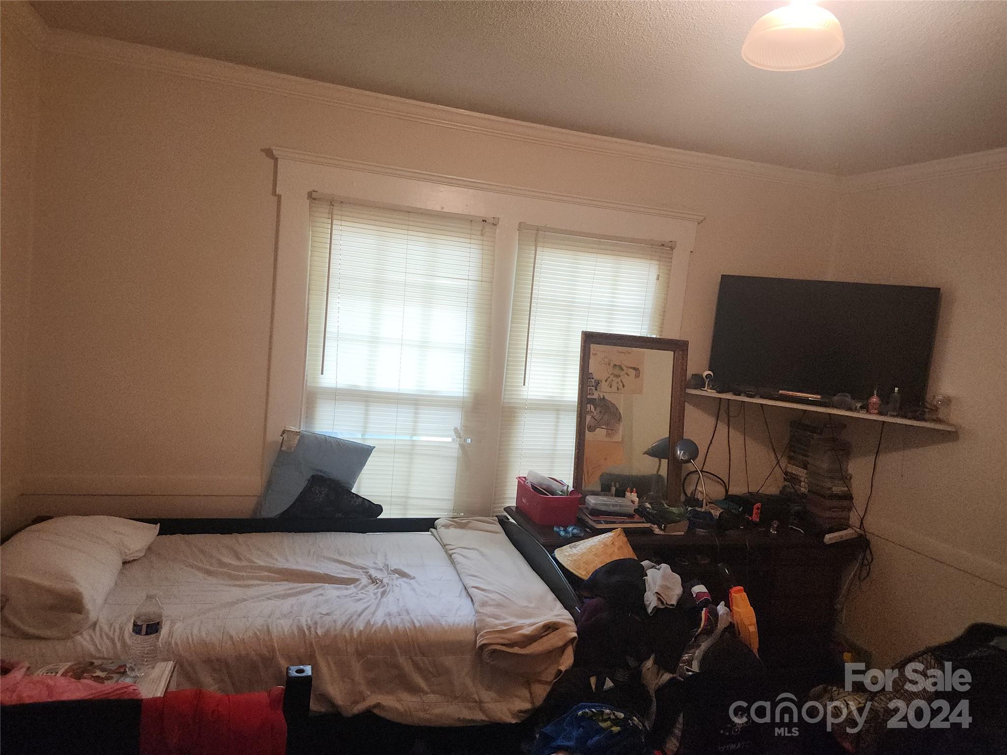 4616 Hovis Road Charlotte, NC 28208 - Photo 6 of 14 a bedroom with a bed and flat screen tv