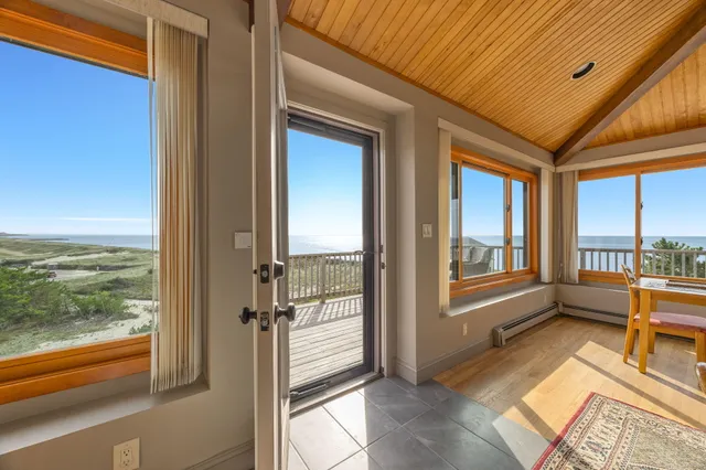 a view of a hallway with wooden floor and windows