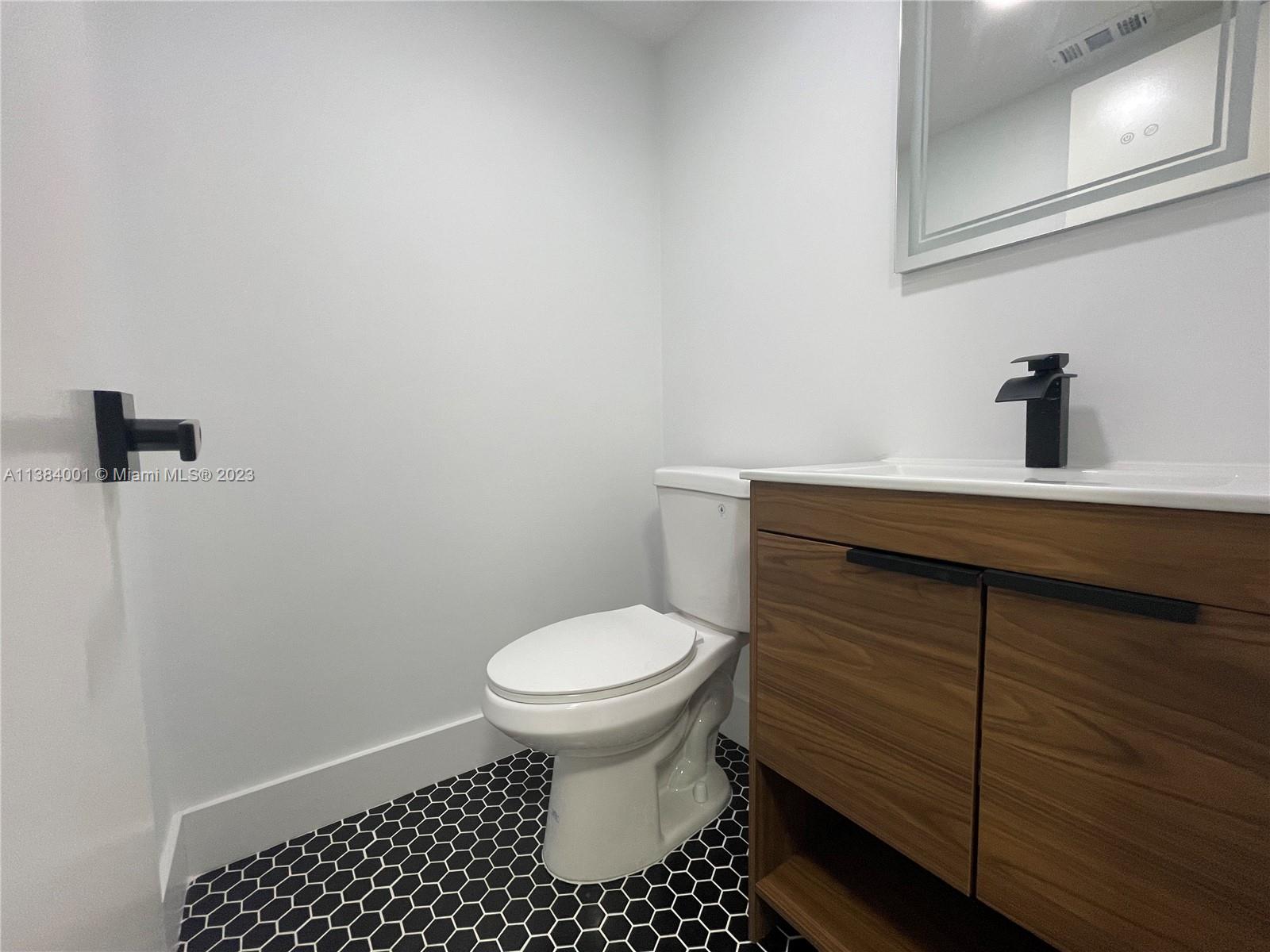 7765 Southwest 86th Street, Unit F2412 Miami, FL 33143 - Photo 19 of 53 a bathroom with a sink toilet and vanity