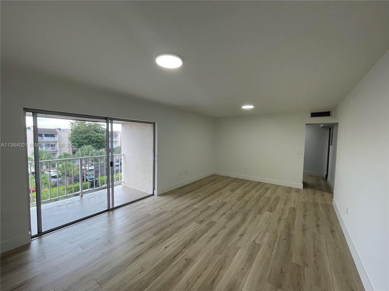 7765 Southwest 86th Street, Unit F2412 Miami, FL 33143 - Photo 3 of 53 wooden floor in an empty room with a window
