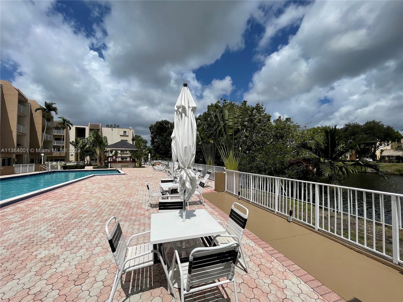 7765 Southwest 86th Street, Unit F2412 Miami, FL 33143 - Photo 46 of 53 a view of a patio with couches table and chairs and potted plants