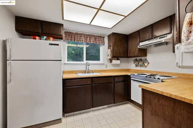 a kitchen with stainless steel appliances granite countertop a refrigerator sink and stove