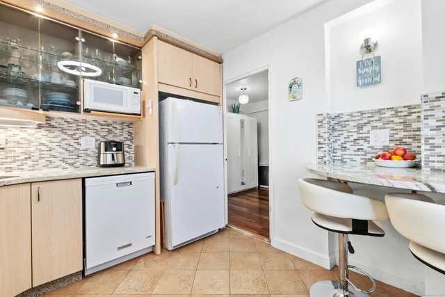 a kitchen with white cabinets and white appliances