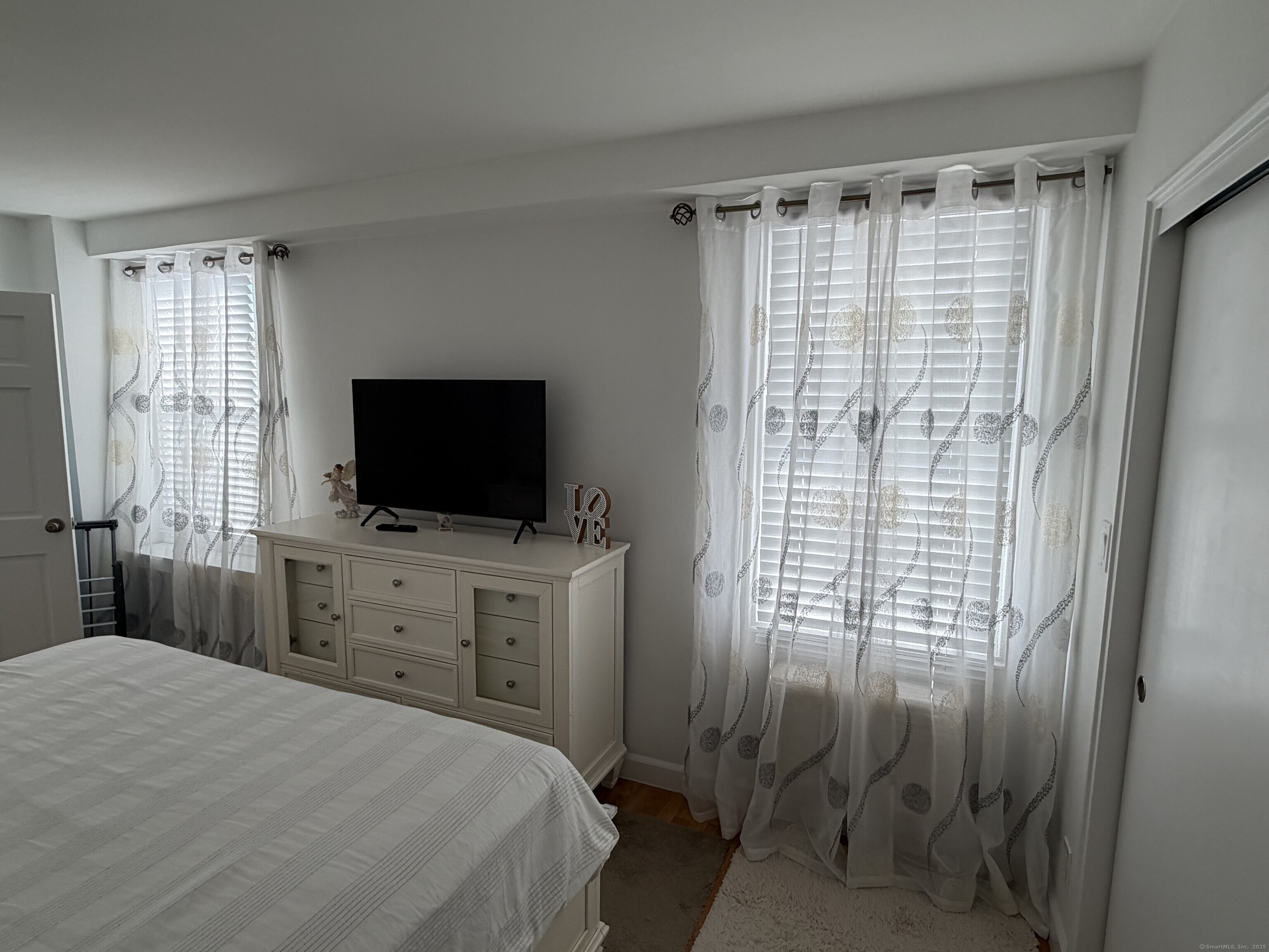 71 Strawberry Hill Avenue, Unit 305 Stamford, CT 06902 - Photo 18 of 29 a bedroom with a bed and a flat screen tv