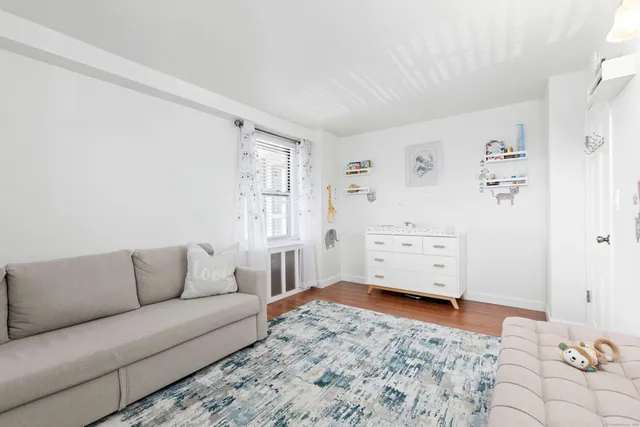 a living room with furniture and dresser