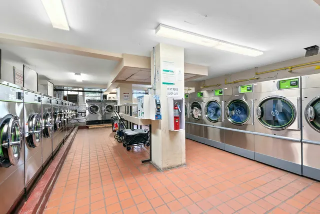 a utility room with stainless steel appliances and living room view