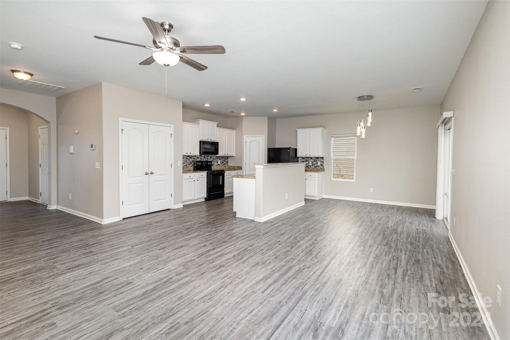 1105 Rook Road Charlotte, NC 28216 - Photo 3 of 14 a view of a kitchen with a wooden floor and a ceiling fan