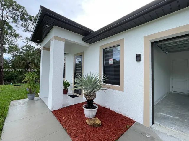 a vase of flowers sitting on a yard in front of a house