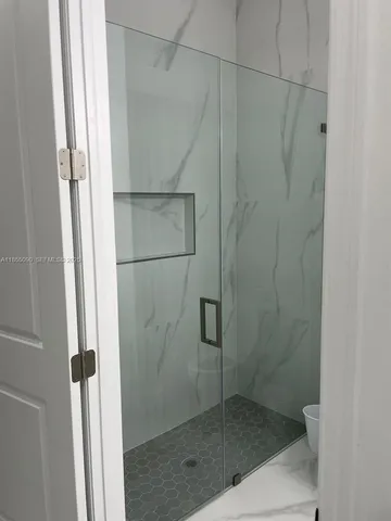 a bathroom with a glass shower door