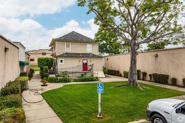 a front view of a house with a garden and plants