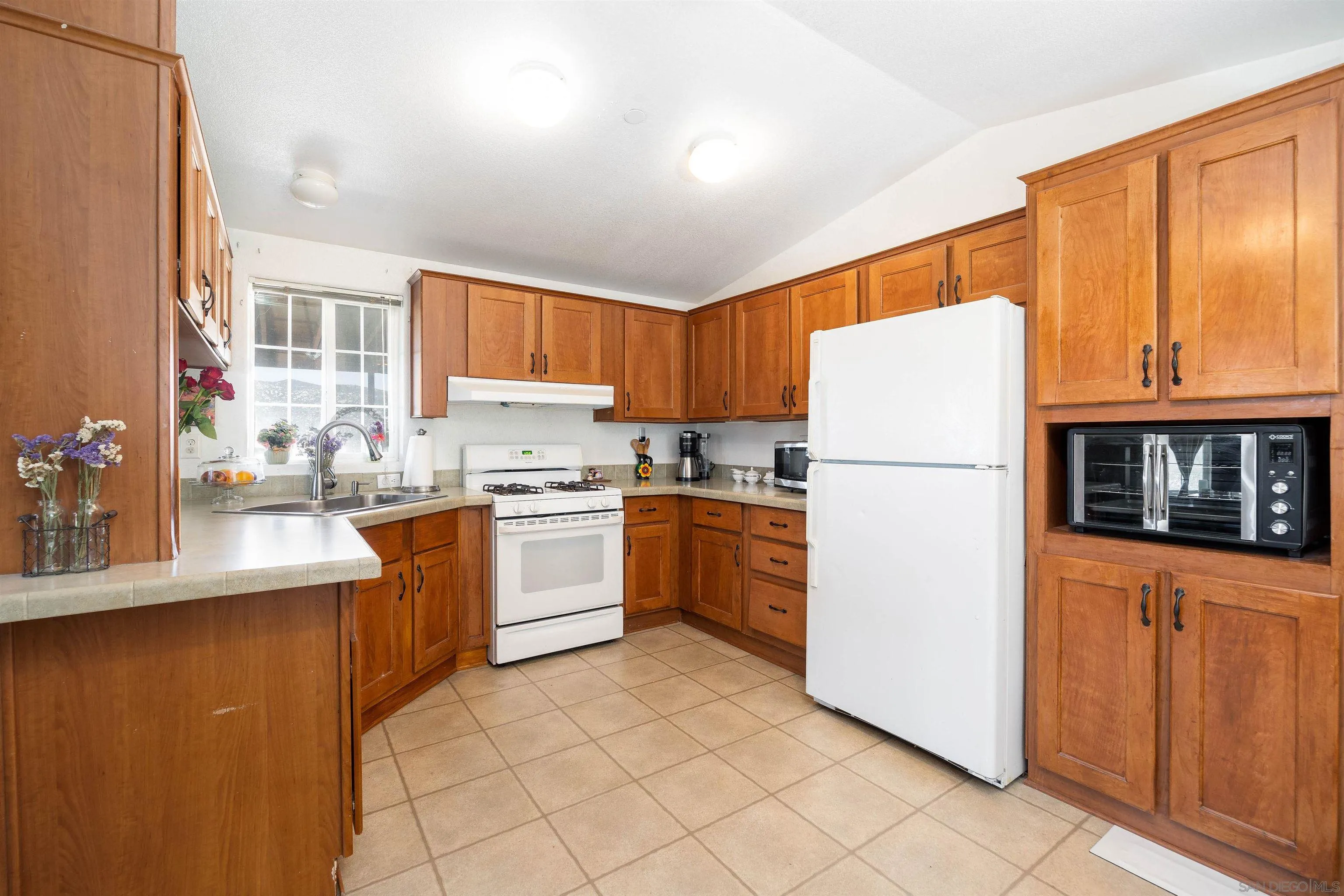 23744 Old Ranch Road Alpine, CA 91901 - Photo 2 of 17 a kitchen with granite countertop a refrigerator a stove a sink a counter space and cabinets