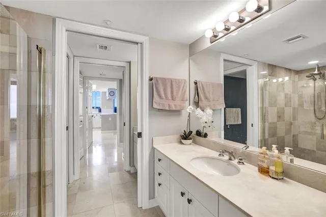 a bathroom with a granite countertop sink a shower and a mirror