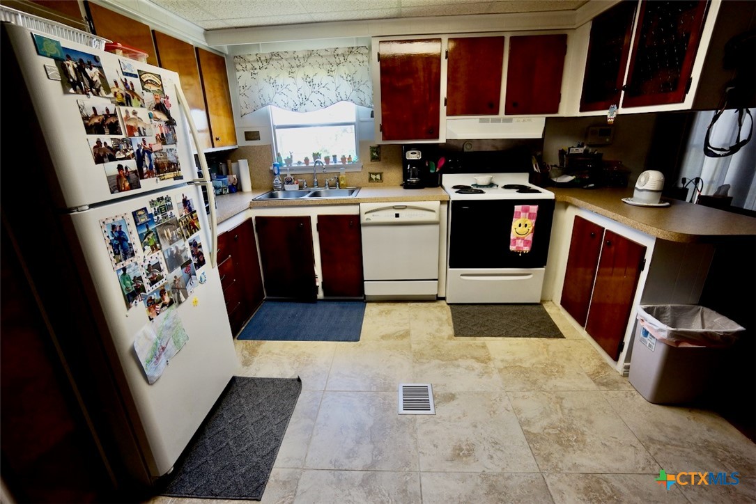 513 16th Street Port O'Connor, TX 77982 - Photo 21 of 35 a kitchen with stainless steel appliances granite countertop a sink stove and refrigerator