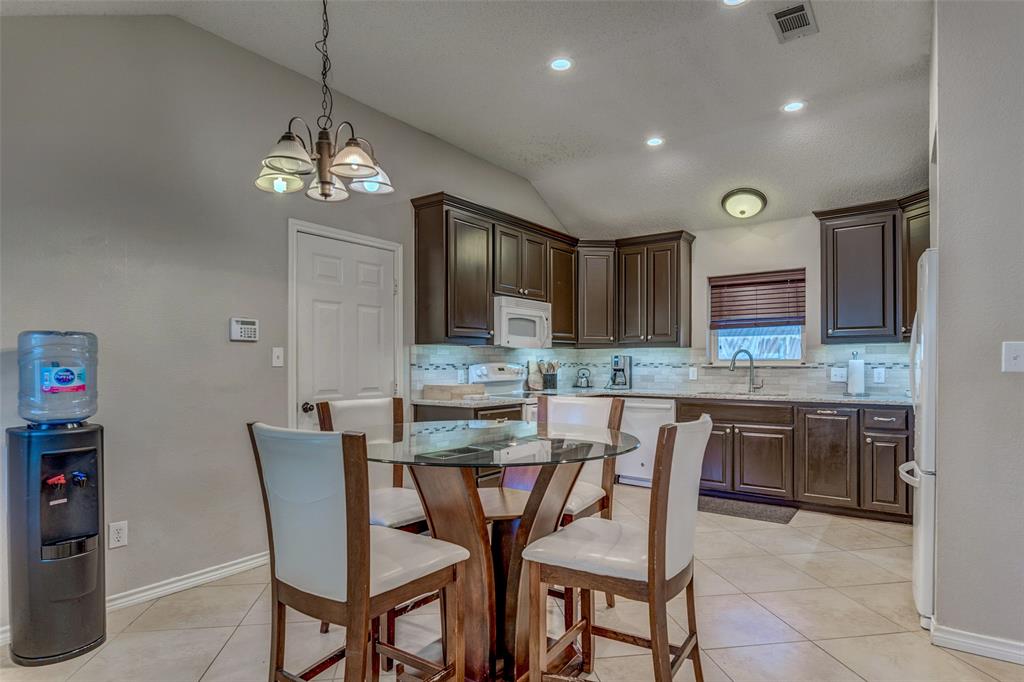 11812 Canoe Road Frisco, TX 75035 - Photo 17 of 31 a view of a dining room and kitchen with a chandelier