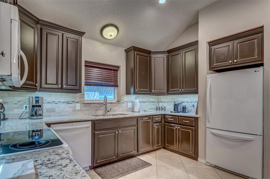 11812 Canoe Road Frisco, TX 75035 - Photo 20 of 31 a kitchen with stainless steel appliances granite countertop a sink stove and refrigerator