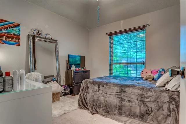 a bed sitting in a bedroom next to a window