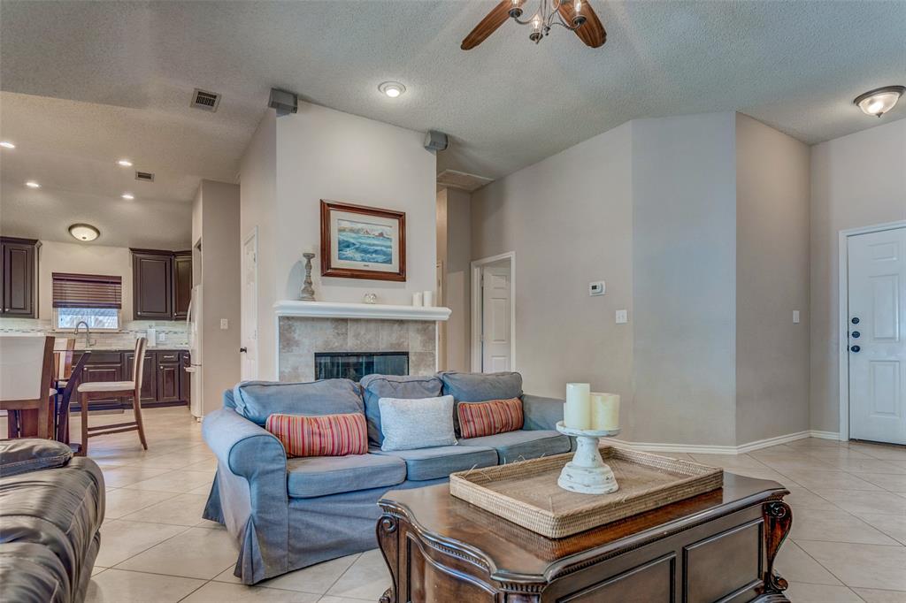 11812 Canoe Road Frisco, TX 75035 - Photo 9 of 31 a living room with furniture a fireplace and a chandelier