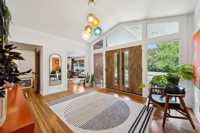 a living room with chairs kitchen view and a dining table