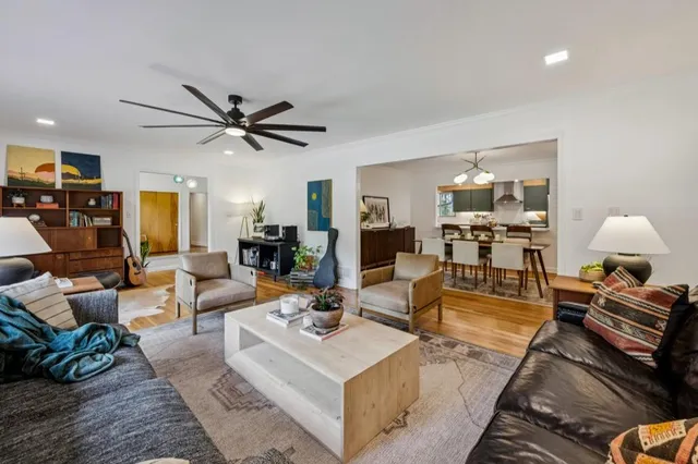 a living room with furniture kitchen and a chandelier