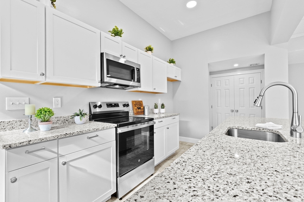 a kitchen with stainless steel appliances granite countertop a sink a stove a microwave and cabinets