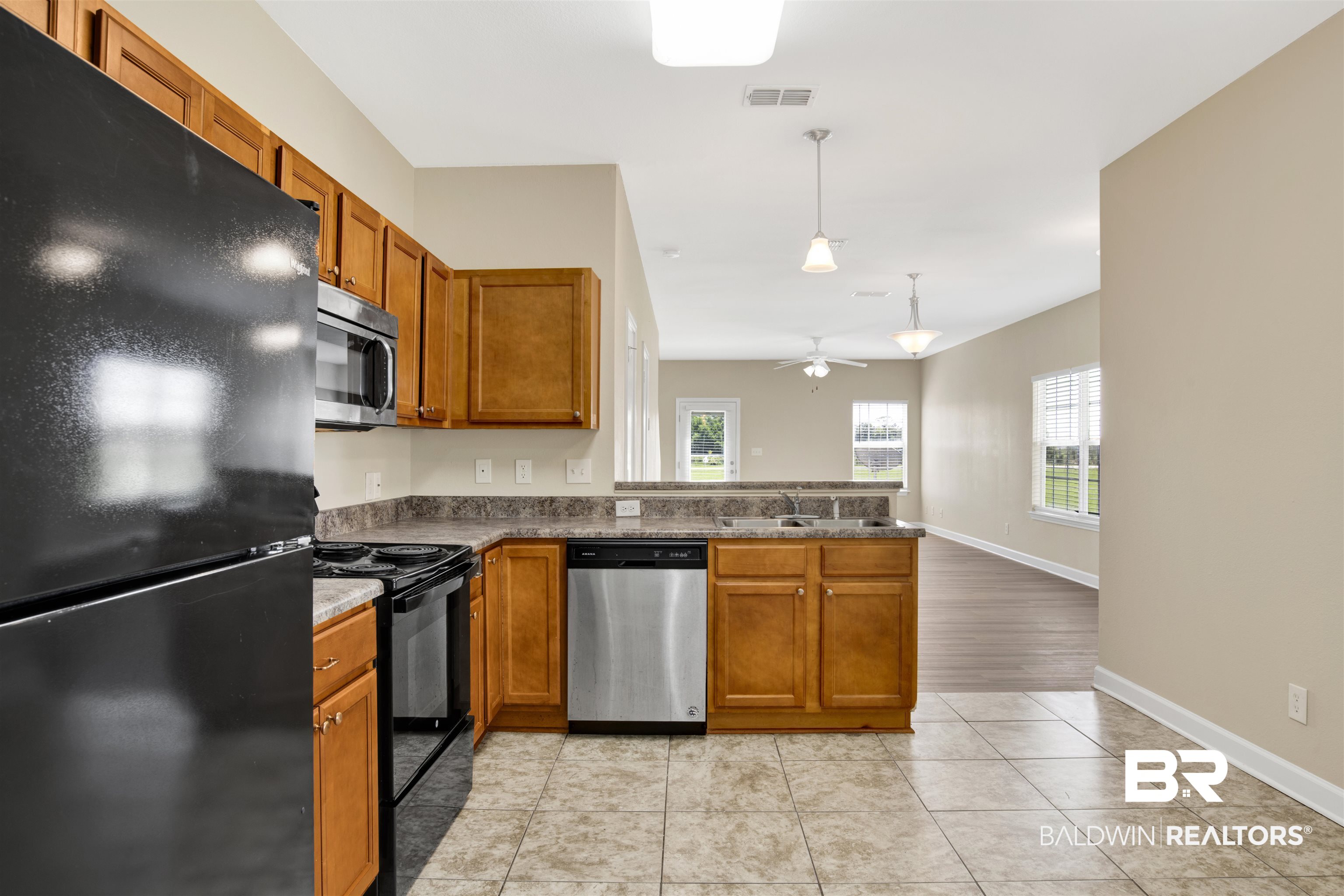 2002 Shelene Way Foley, AL 36535 - Photo 9 of 23 Kitchen featuring black appliances, brown cabinets, hanging light fixtures, and a peninsula