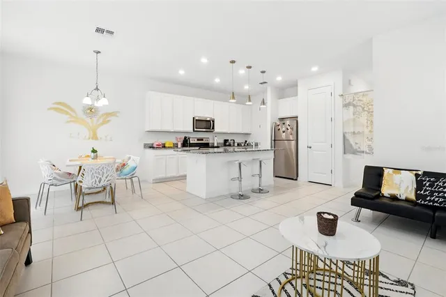 a kitchen with granite countertop a stove a sink and a refrigerator