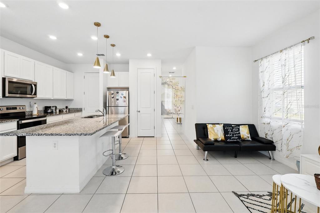 1421 Discovery Street Davenport, FL 33896 - Photo 17 of 44 a kitchen with granite countertop a stove a sink and a refrigerator