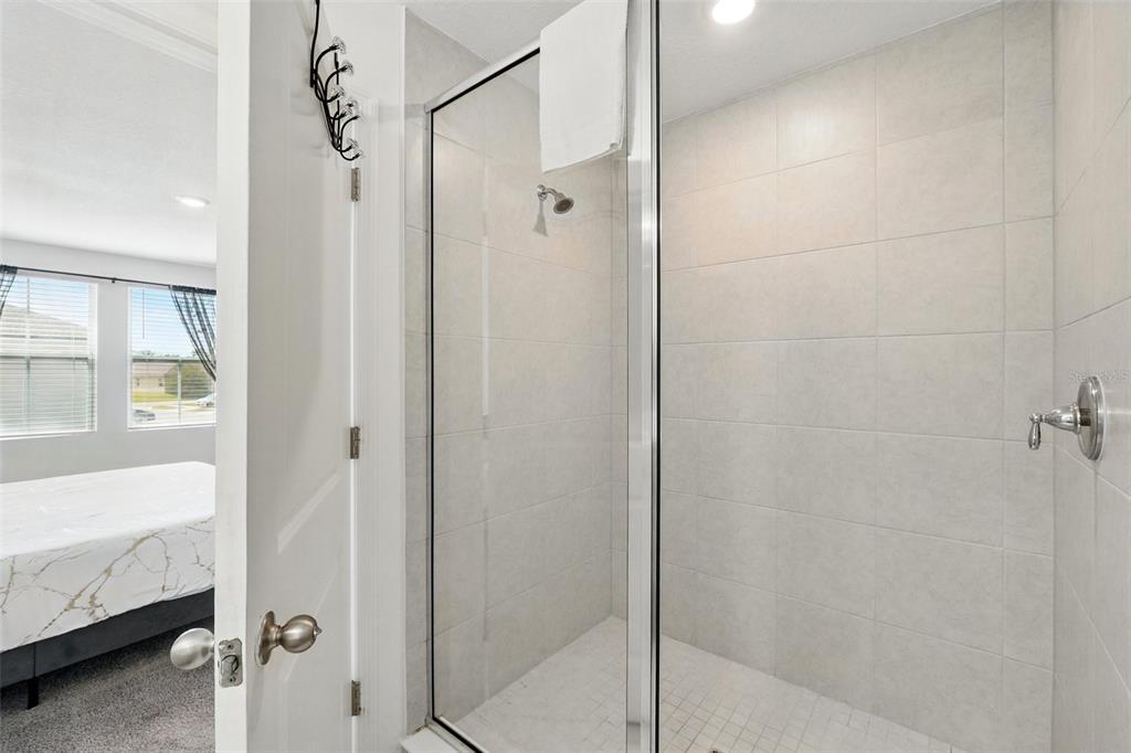 1421 Discovery Street Davenport, FL 33896 - Photo 26 of 44 a bathroom with a bathtub and a shower