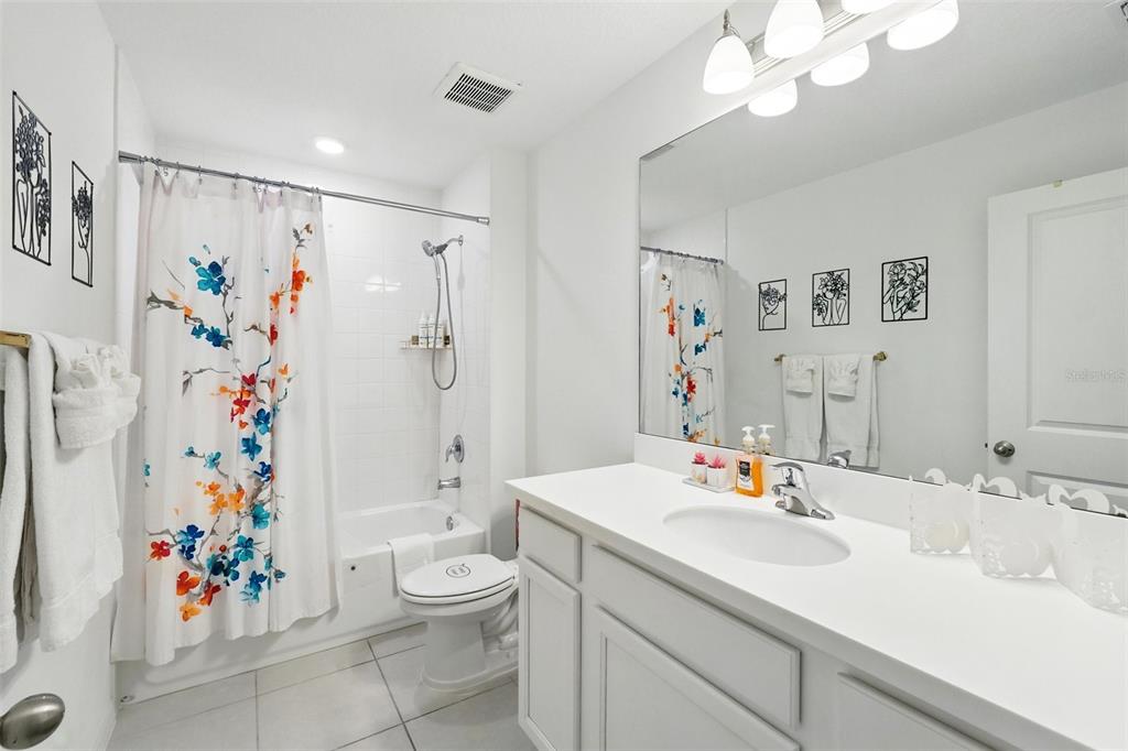 1421 Discovery Street Davenport, FL 33896 - Photo 29 of 44 a bathroom with a sink a toilet and a shower curtain