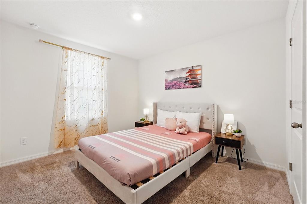 1421 Discovery Street Davenport, FL 33896 - Photo 30 of 44 a bedroom with a bed and a window